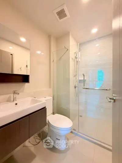 Modern bathroom with glass shower and sleek fixtures in a contemporary apartment.