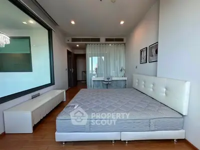 Spacious modern bedroom with large window and stylish decor