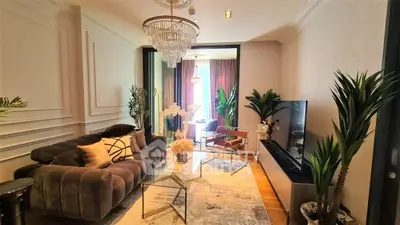 Luxurious living room with elegant decor and large TV, perfect for relaxation and entertainment.