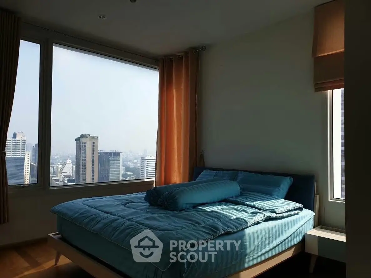 Spacious bedroom with city view and large windows in modern apartment