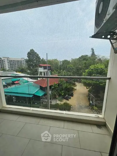 Spacious balcony with serene garden view in modern apartment