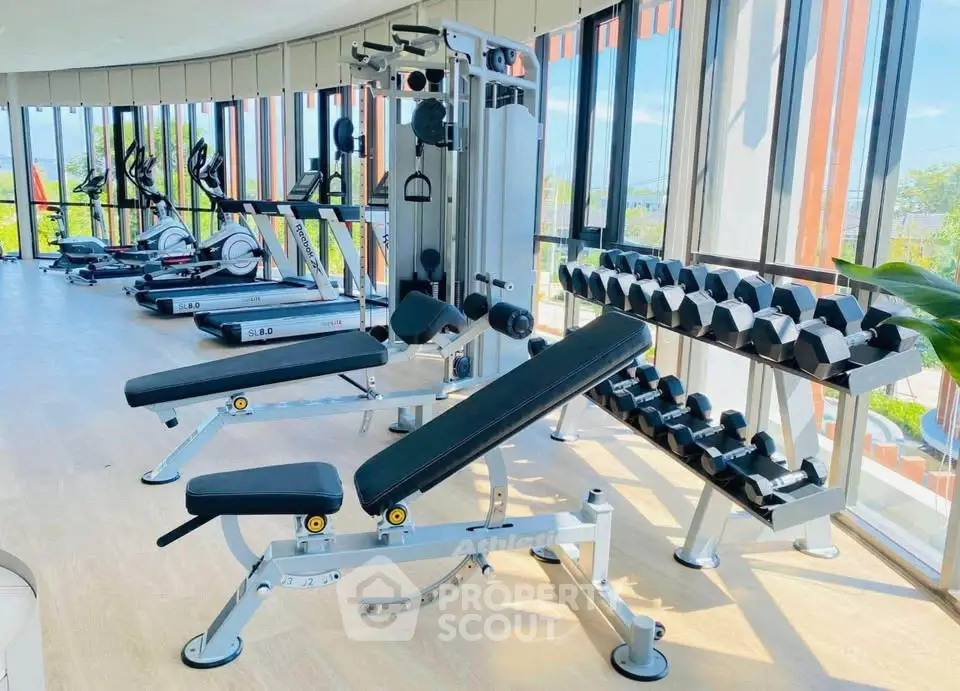 Modern gym with state-of-the-art equipment and panoramic windows in luxury real estate property.