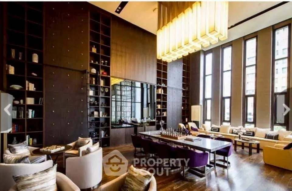 Luxurious living room with high ceilings, elegant chandelier, and modern decor in upscale apartment.