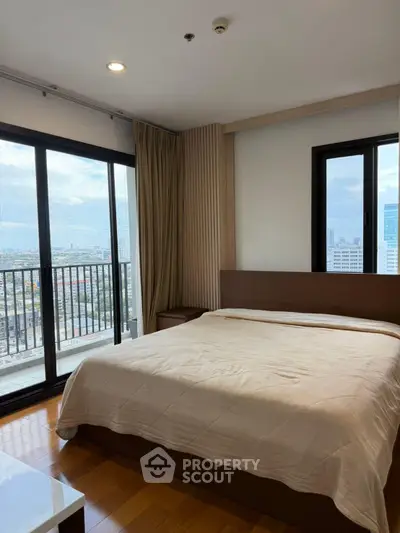 Spacious bedroom with city view and balcony access in modern apartment