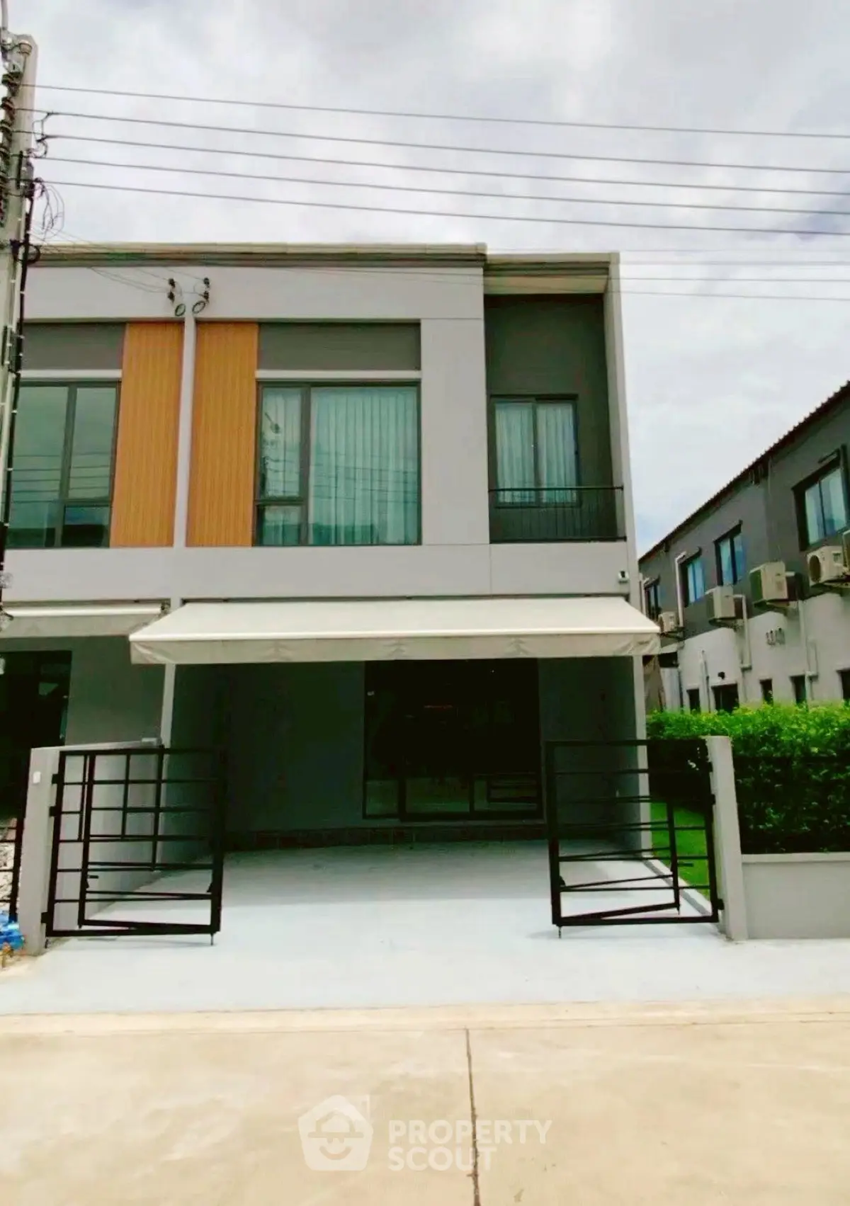 Modern two-story townhouse with sleek facade and gated driveway