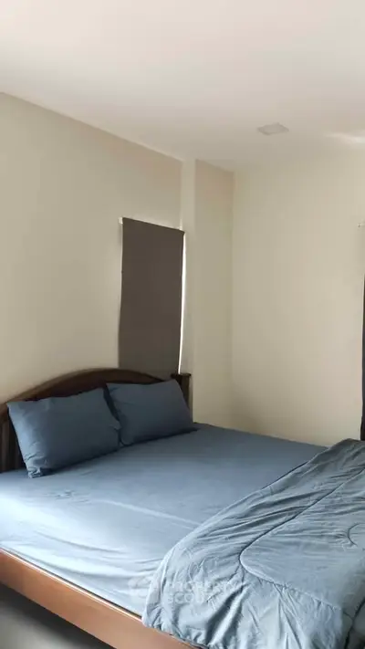Cozy bedroom with minimalist design and soft blue bedding, perfect for relaxation.