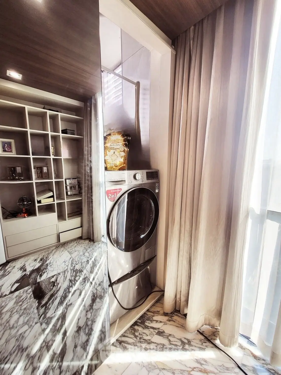 Modern laundry area with washer and marble flooring in stylish apartment.