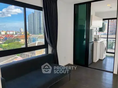 Modern apartment with city view, featuring sleek living room and kitchen with washing machine.