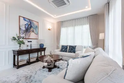 Elegant living room with plush sofas, stylish decor, and natural light.