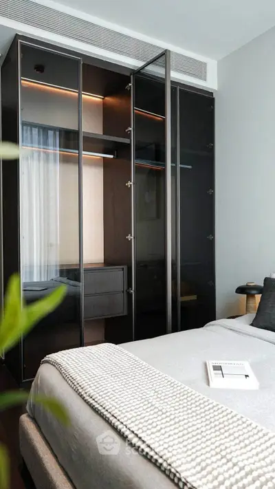 Modern bedroom with sleek glass wardrobe and cozy bedding