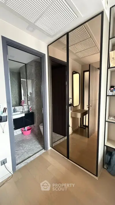 Modern apartment interior with mirrored closet and sleek bathroom design