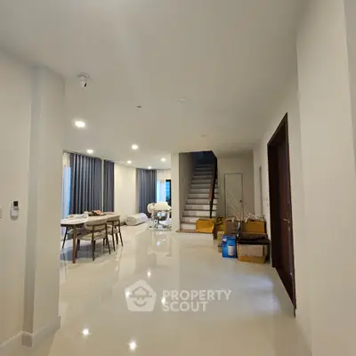 Spacious modern living room with dining area and staircase in elegant home