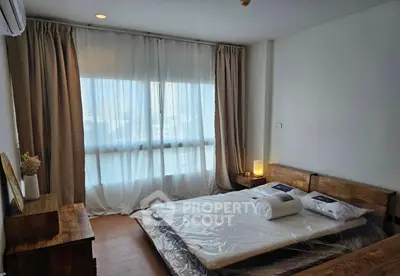 Cozy bedroom with wooden furniture and large window for natural light