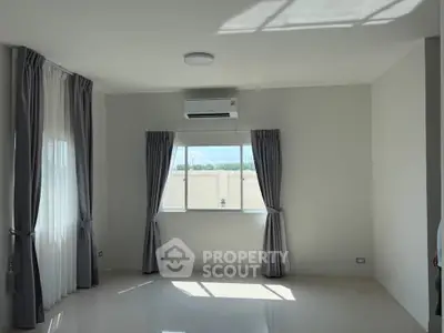 Bright and airy unfurnished room with large windows and air conditioning, perfect for customization.