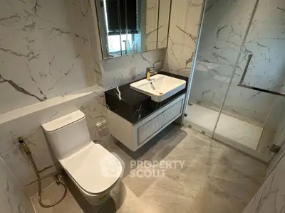 Luxurious modern bathroom with marble tiles and glass shower enclosure