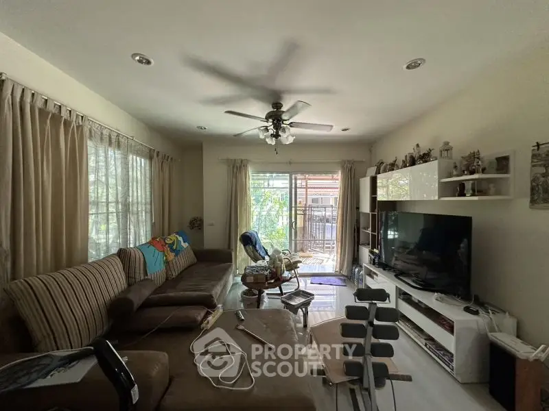 Cozy living room with large TV and comfortable seating, perfect for relaxation.