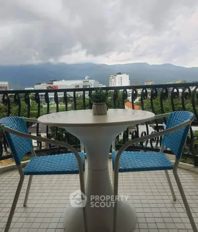 Charming balcony with mountain view, featuring modern table and chairs, perfect for relaxation.
