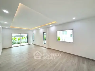 Spacious modern living room with recessed lighting and large windows