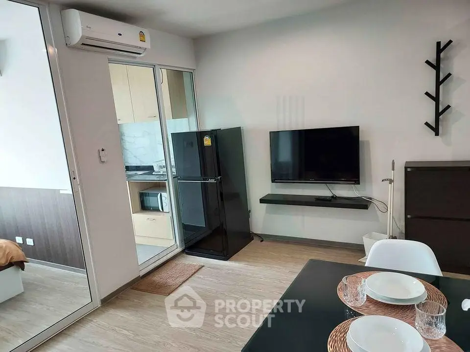 Modern apartment interior with open kitchen and living area, featuring sleek appliances and stylish decor.