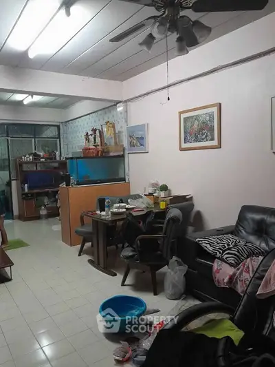 Cozy living room with ceiling fan and aquarium, ideal for relaxation.