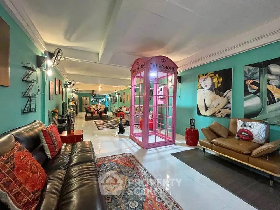 Stylish living room with unique pink telephone booth and vibrant decor