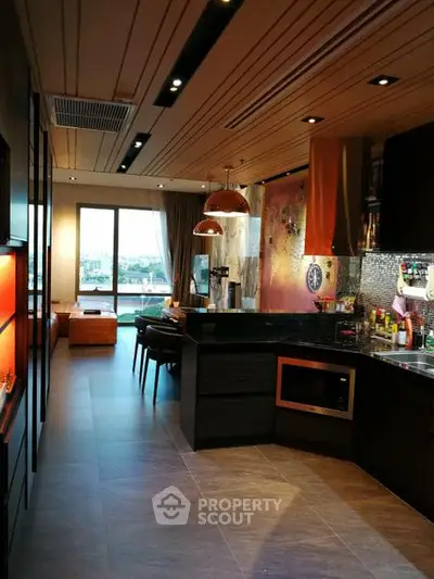 Modern open-layout kitchen with stylish lighting and spacious living area