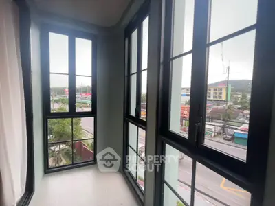 Spacious corner balcony with large windows offering panoramic city views.
