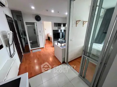 Modern apartment interior with open layout, featuring a kitchen and bedroom with sleek design.