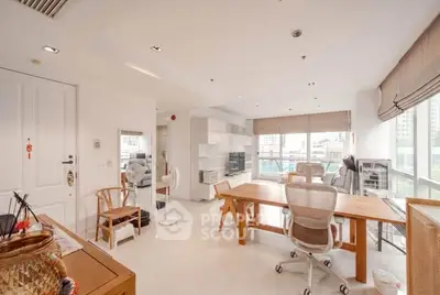 Spacious modern living room with large windows and stylish furniture in a high-rise apartment.
