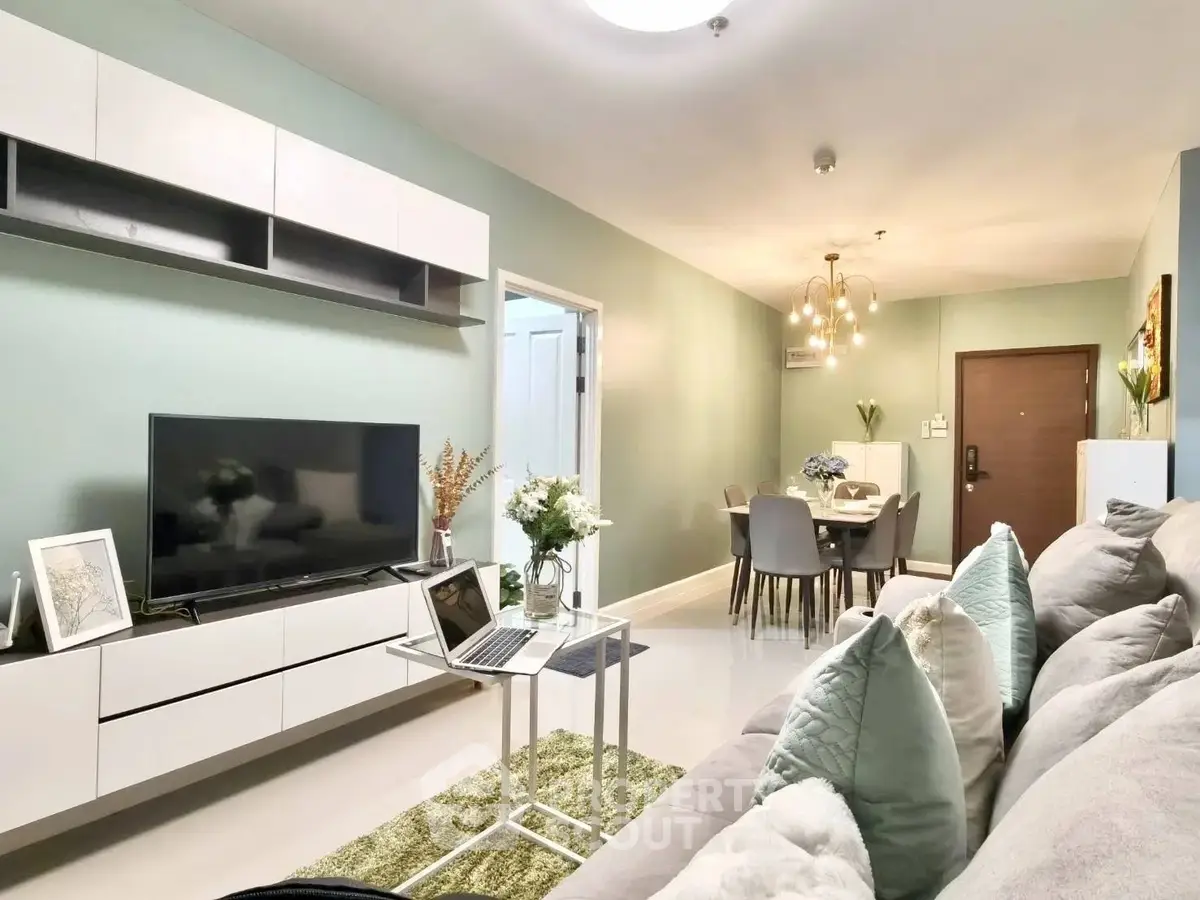 Modern living room with stylish decor and open dining area, featuring sleek furniture and ambient lighting.