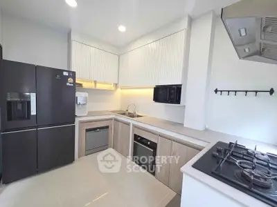 Modern kitchen with sleek appliances and gas stove in a stylish open layout.