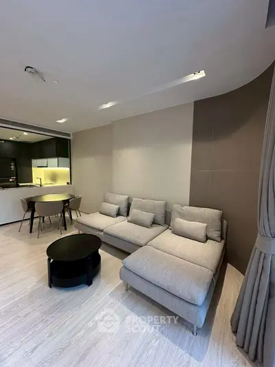 Modern living room with sleek furniture and open kitchen layout