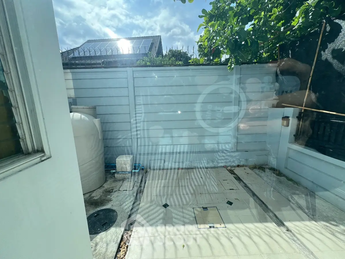 Charming outdoor space with privacy fence and lush greenery, perfect for relaxation and outdoor activities.