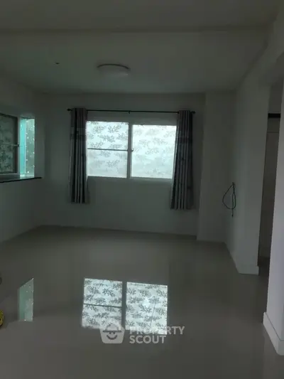 Spacious empty room with large windows and glossy floor, perfect for customization.