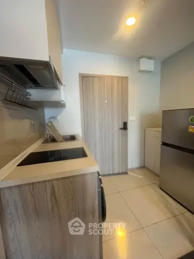 Modern kitchen with sleek design and stainless steel appliances in a contemporary apartment.