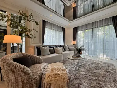 Luxurious living room with plush seating and elegant decor, featuring large windows and abundant natural light.