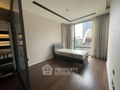 Spacious bedroom with large window and modern design in urban apartment
