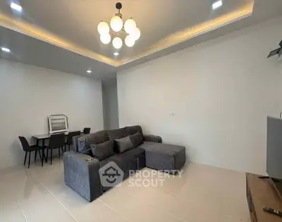 Modern living room with stylish gray sofa and elegant lighting in a spacious open layout.