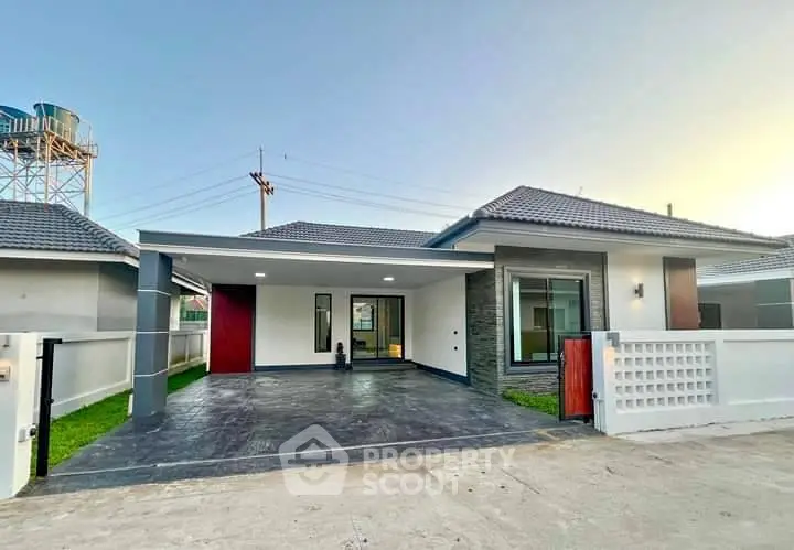 Modern single-story house with spacious driveway and contemporary design.