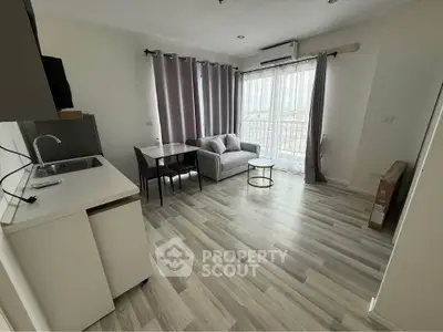 Modern living room with sleek flooring, cozy sofa, and large window offering natural light.