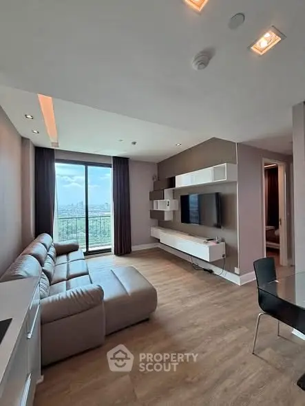Modern living room with large window and stylish furniture in high-rise apartment