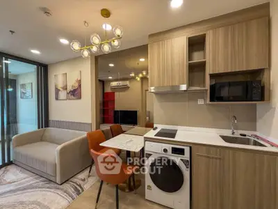 Modern open-plan living room with kitchen, featuring stylish furniture and contemporary lighting.