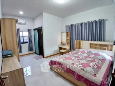 Spacious bedroom with modern furniture and cozy decor in a well-lit interior.