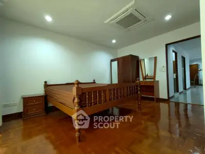 Spacious bedroom with wooden furniture and polished flooring