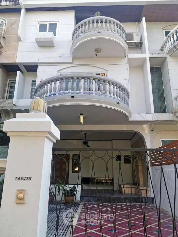 Elegant multi-story building with distinctive balconies and gated entrance, perfect for urban living.