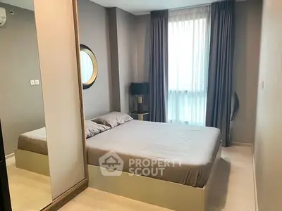 Modern bedroom with large window and stylish decor in a contemporary apartment.