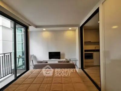 Modern studio apartment with open layout, featuring a cozy living area and sleek kitchen.
