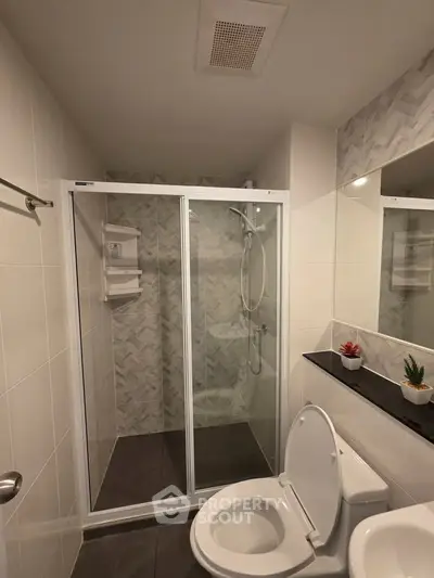 Modern bathroom with glass shower enclosure and sleek fixtures