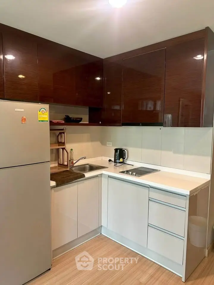 Modern kitchen with sleek cabinetry and stainless steel appliances in a compact layout.