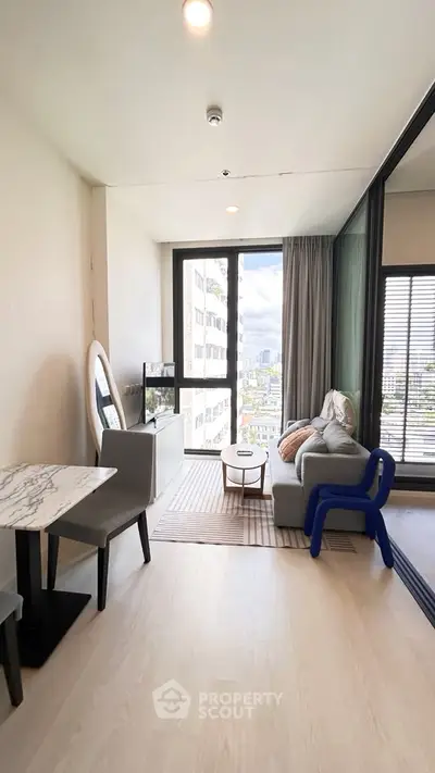 Modern living room with city view, stylish furniture, and natural light.